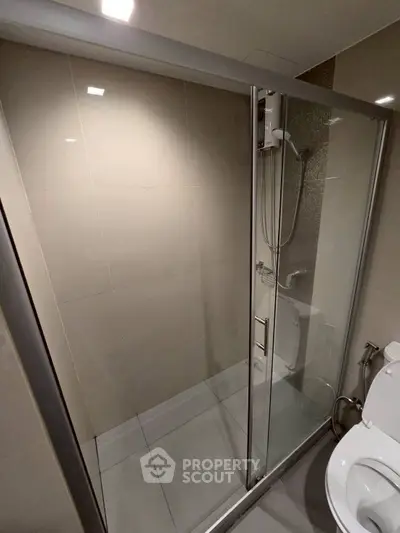 Modern bathroom with glass shower enclosure and sleek fixtures