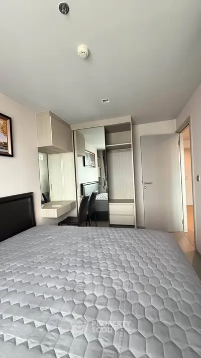 Modern bedroom with stylish furniture and ample storage space in a contemporary apartment.