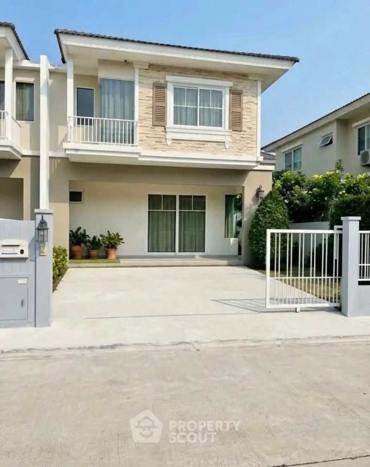 Modern two-story house with spacious driveway and balcony in a serene neighborhood.