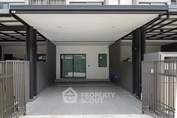 Modern covered parking space with sleek design and gated entrance