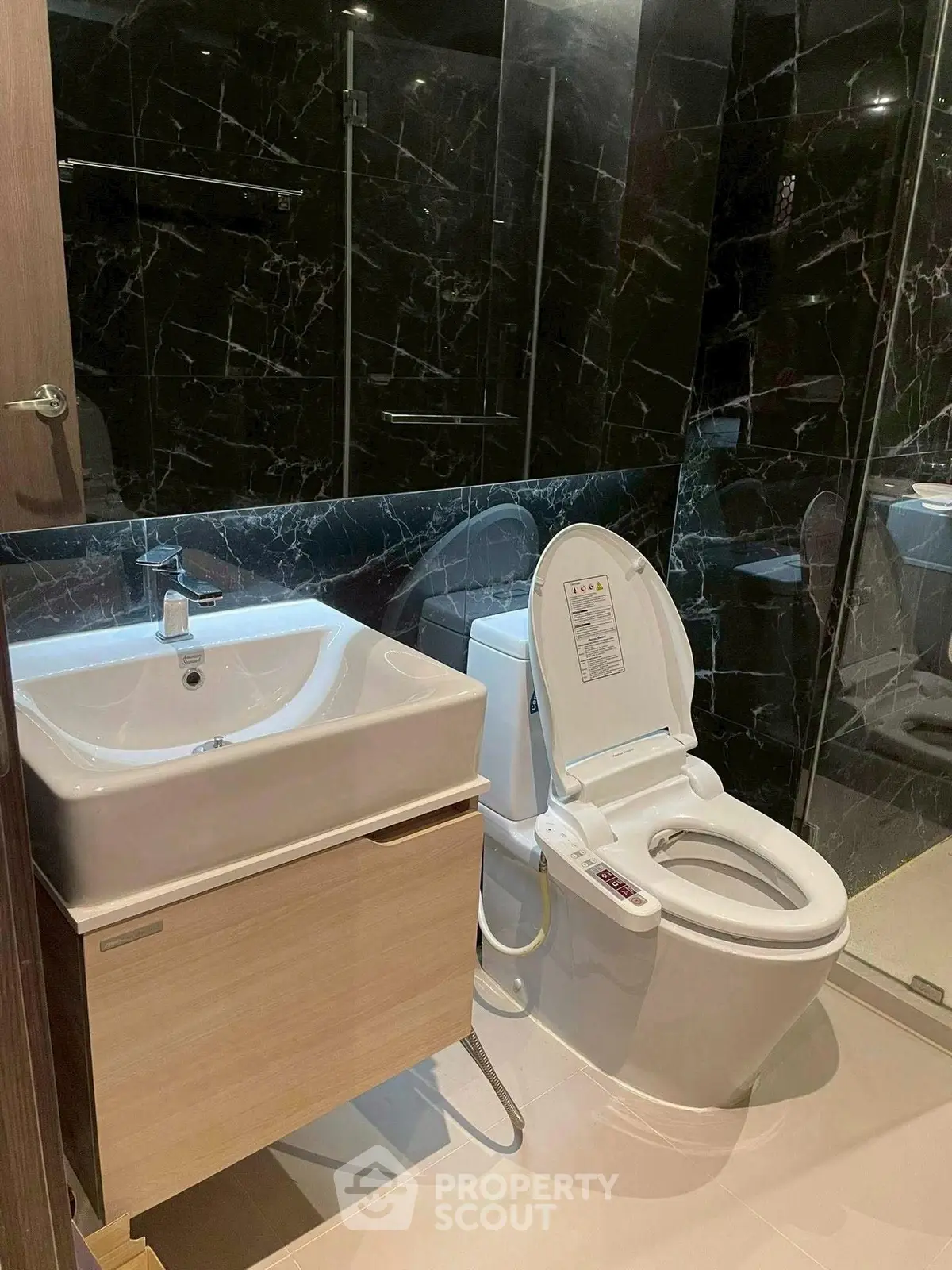 Luxurious modern bathroom with sleek black marble walls and high-end fixtures.