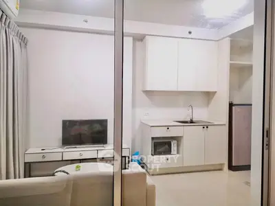 Modern studio apartment with compact kitchen and cozy living area, perfect for urban living.