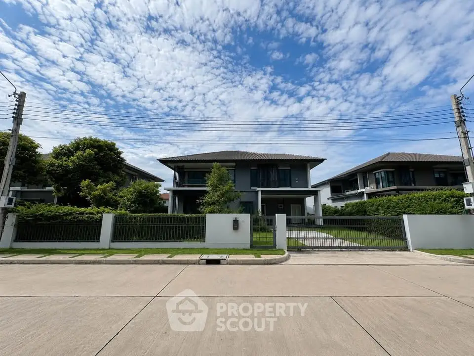 Stunning modern house with lush greenery and clear blue sky, perfect for serene living.