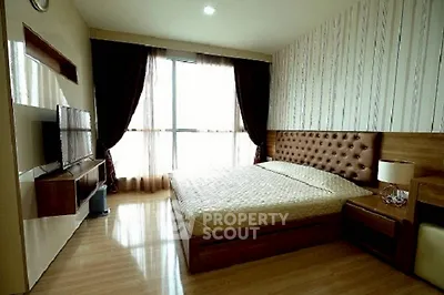 Modern bedroom with stylish decor and large window offering natural light.
