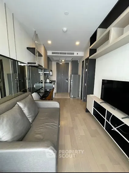 Modern living room with sleek furniture and built-in shelving in a contemporary apartment.