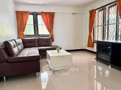 Spacious living room with modern brown sofa and large windows