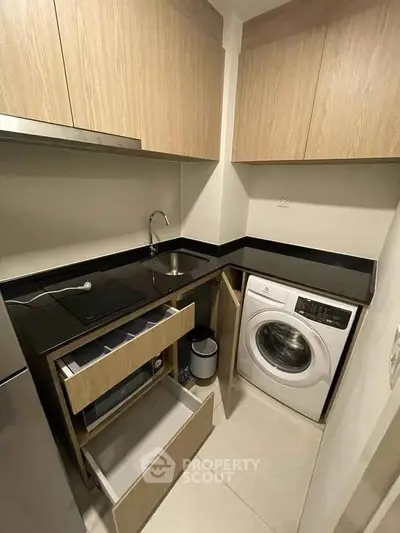 Modern compact kitchen with washing machine and sleek cabinetry