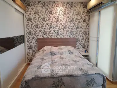 Cozy bedroom with stylish wallpaper and comfortable bedding in modern apartment.