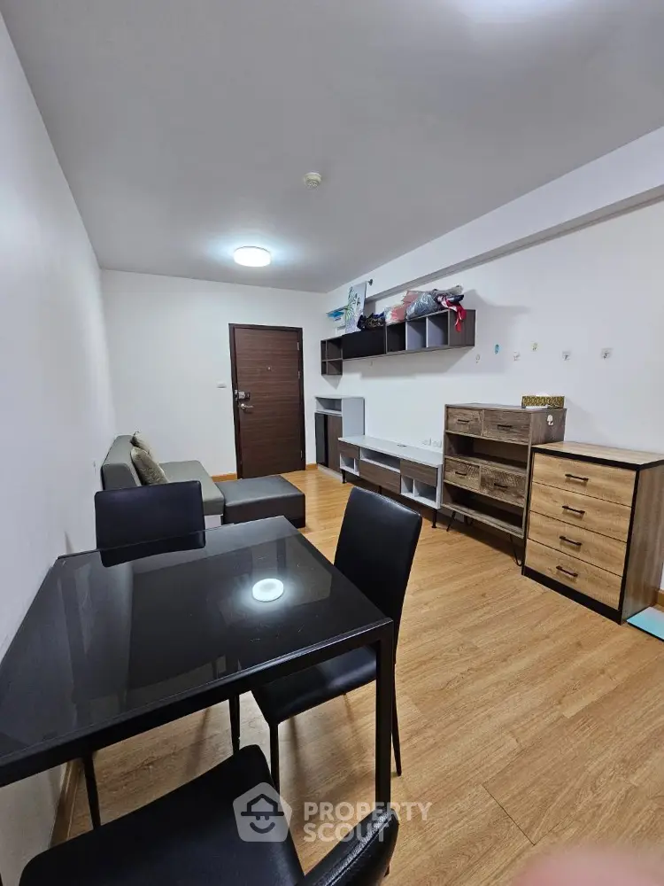 Modern living room with sleek furniture and wooden flooring in a cozy apartment.