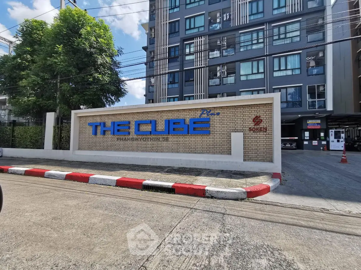 Modern condominium entrance with sleek design and prominent signage, showcasing urban living at its finest.