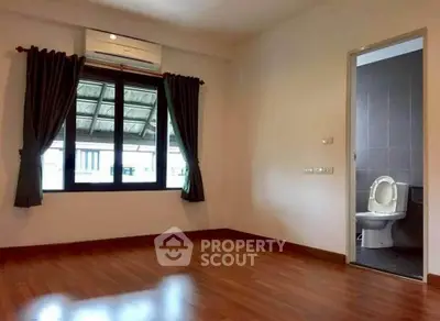 Spacious bedroom with ensuite bathroom and wooden flooring