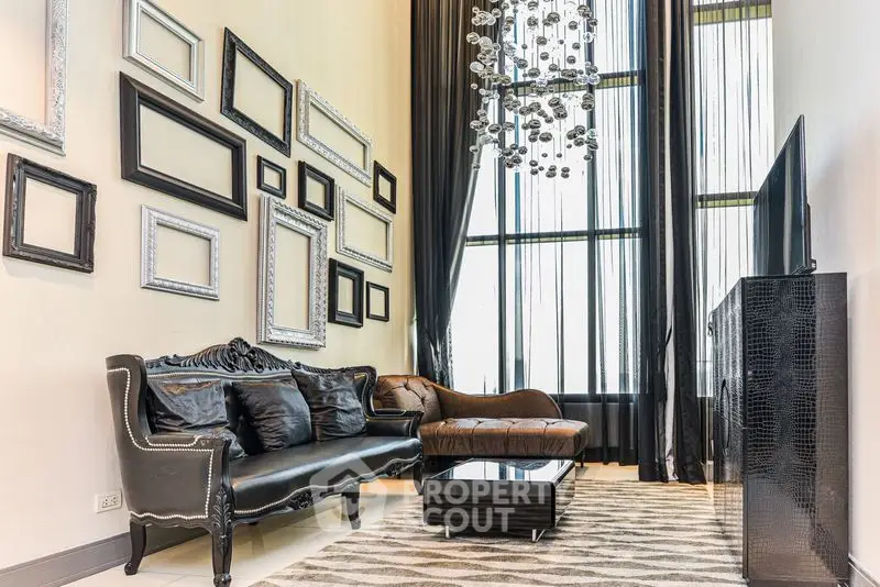 Luxurious living room with high ceilings, elegant chandelier, and stylish decor.