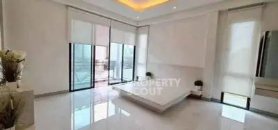 Spacious modern bedroom with large windows and balcony access, featuring minimalist design and natural light.