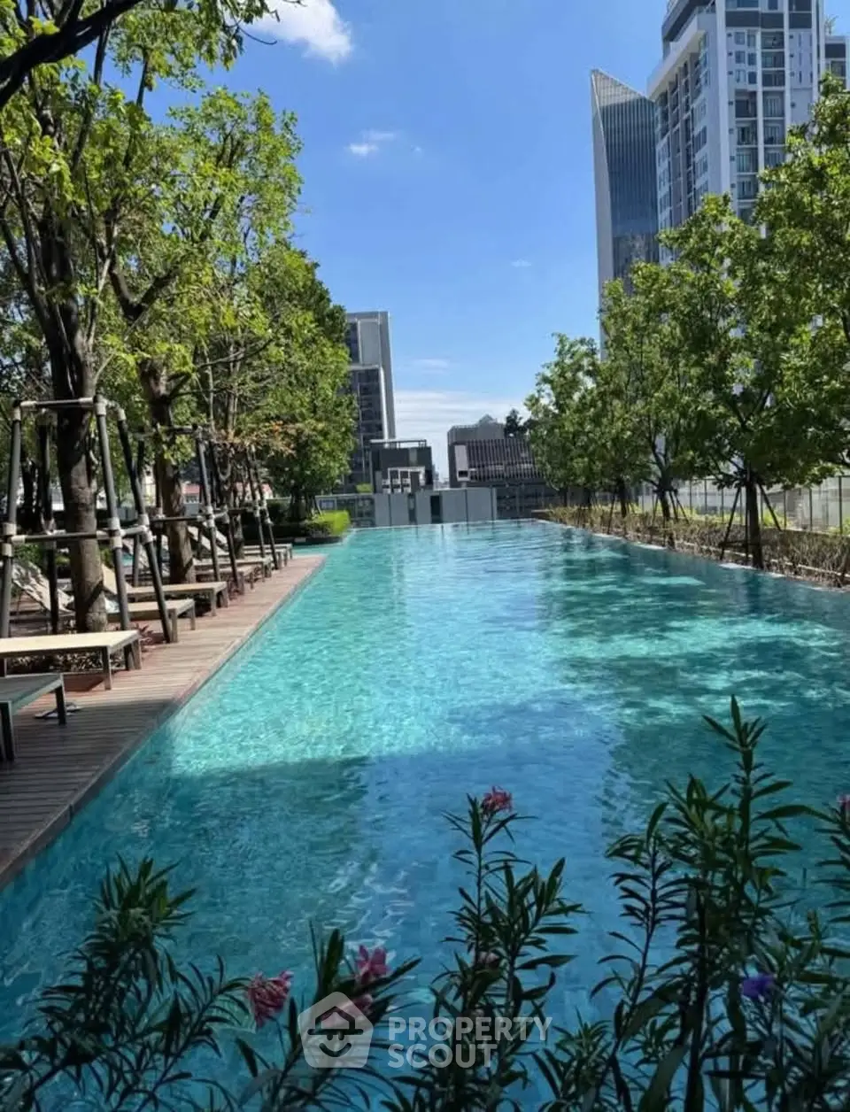 Luxurious rooftop pool with stunning cityscape views and lush greenery.