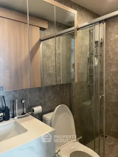 Modern bathroom with glass shower and marble accents