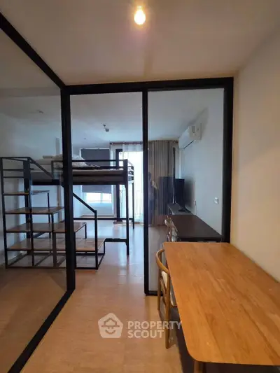Modern studio apartment with loft bed and workspace, ideal for urban living.