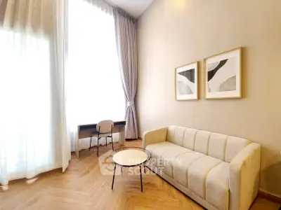 Elegant living room with modern sofa, stylish decor, and large window for natural light.