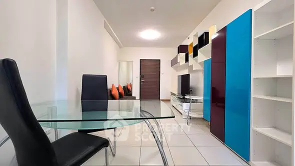 Modern living room with sleek furniture and vibrant accents in a stylish apartment.
