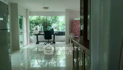 Spacious home office with large windows and garden view, perfect for productivity and relaxation.
