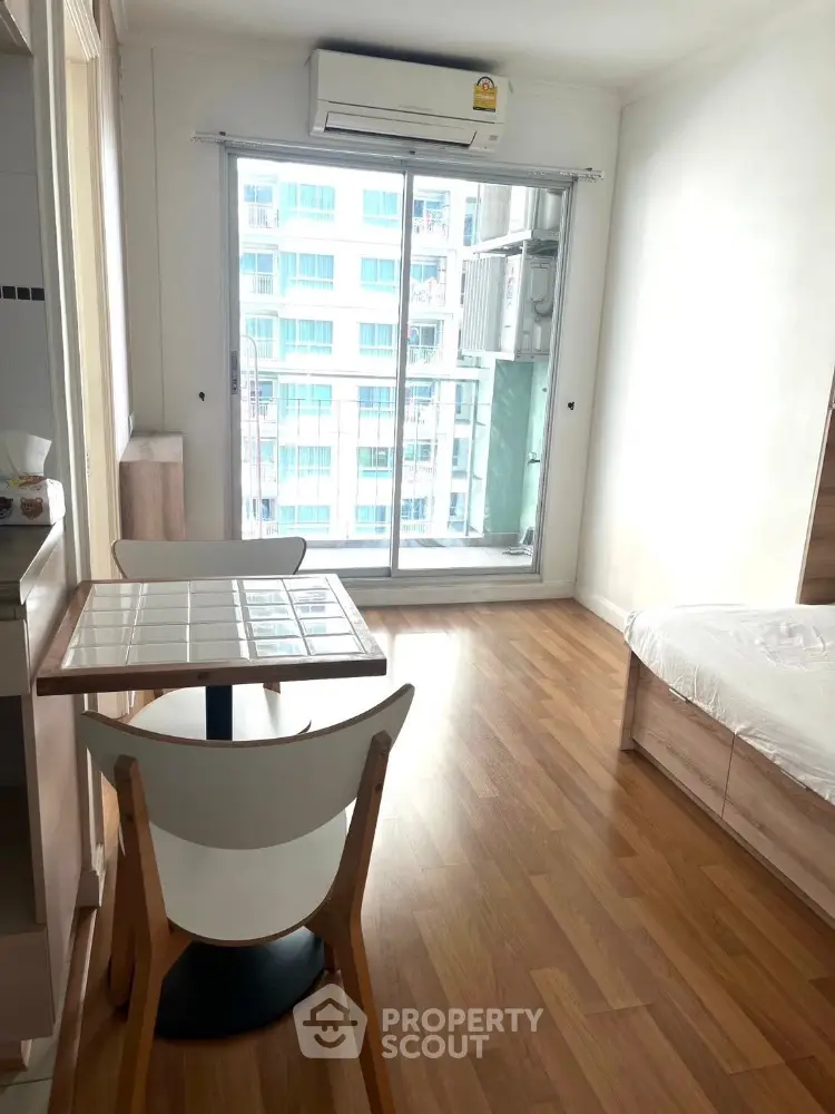 Bright studio apartment with wooden flooring and balcony view