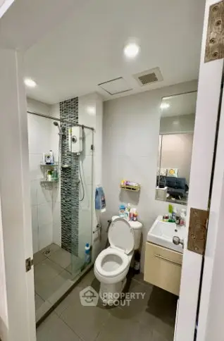 Modern bathroom with glass shower and sleek fixtures in a contemporary apartment.
