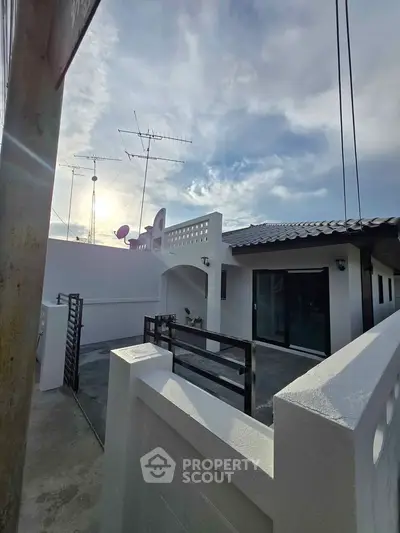 Charming single-story home with modern exterior and rooftop antennas, perfect for urban living.