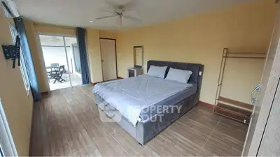 Spacious bedroom with modern decor and balcony access in a stylish apartment.