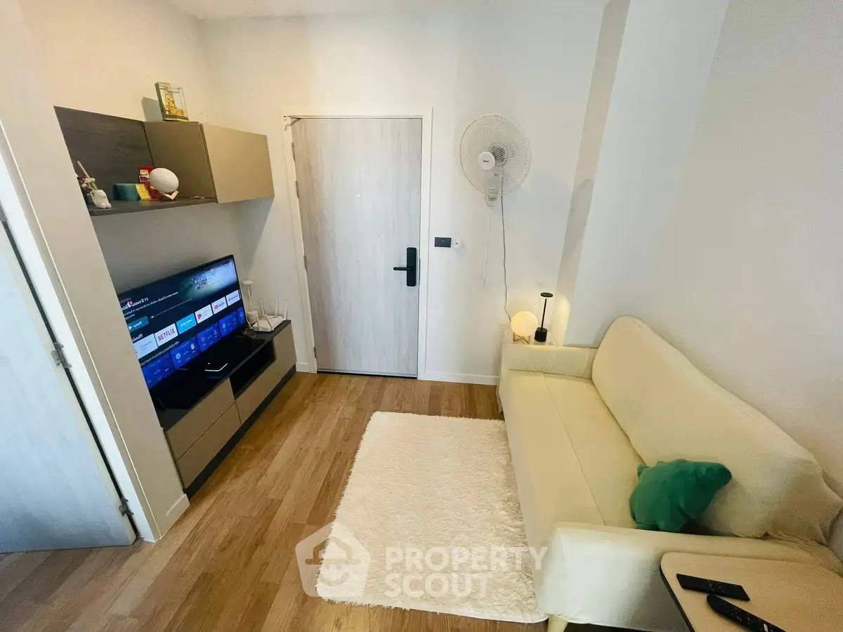 Cozy living room with modern decor and entertainment setup, featuring a plush sofa and sleek TV unit.