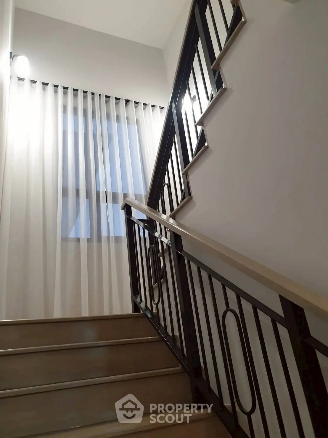 Elegant staircase with modern railing and natural light from window