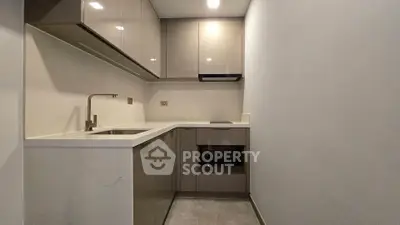 Modern compact kitchen with sleek cabinetry and integrated appliances in a stylish apartment.