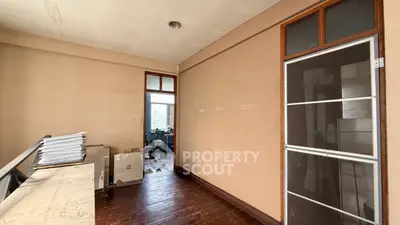 Spacious interior with potential for renovation, featuring wooden floors and ample natural light.