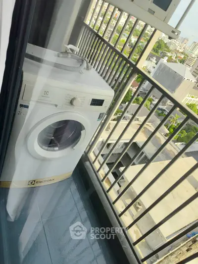 Compact balcony with washing machine and city view, perfect for urban living convenience.