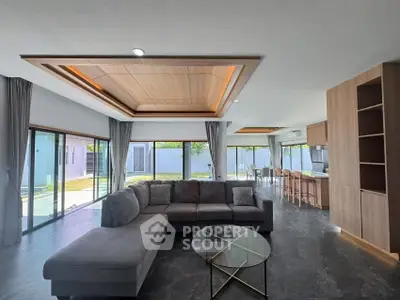 Spacious modern living room with large windows and open kitchen layout
