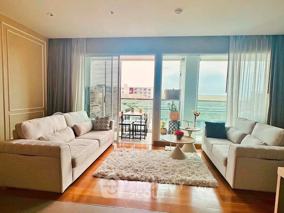 Spacious living room with elegant decor and balcony view, perfect for relaxation.