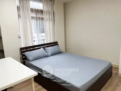 Cozy bedroom with modern bed and natural light, perfect for relaxation and comfort.