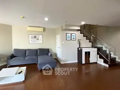 Spacious living room with modern staircase and cozy seating area