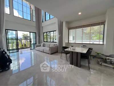Spacious modern living room with high ceilings and large windows offering stunning views.