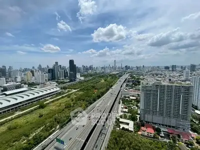 Stunning cityscape view with highway and modern skyscrapers under a vibrant blue sky.