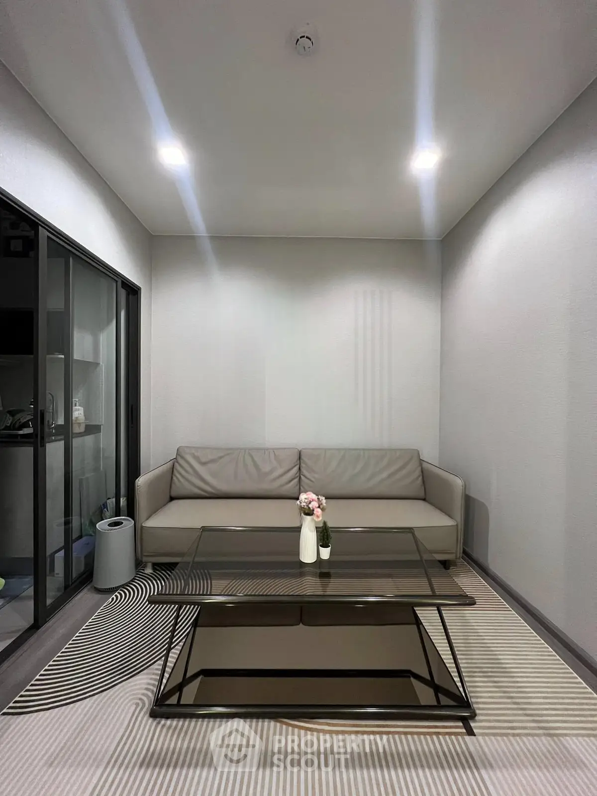 Modern living room with sleek glass coffee table and stylish sofa, perfect for contemporary urban living.