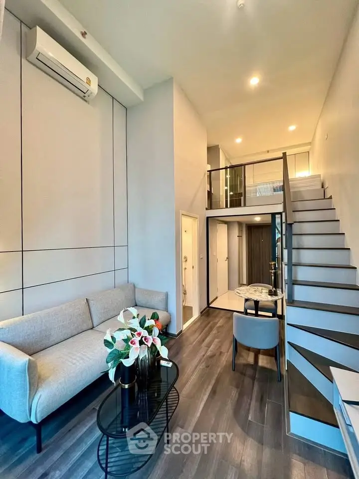 Modern loft-style living room with sleek staircase and elegant decor