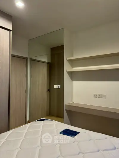 Modern bedroom with built-in wardrobe and minimalist shelving, perfect for urban living.