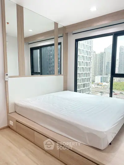 Modern bedroom with large windows offering stunning city views in a high-rise apartment.