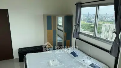 Modern bedroom with city view, featuring a stylish bed and wardrobe, perfect for urban living.