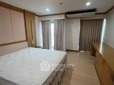 Spacious bedroom with large windows and modern air conditioning unit.