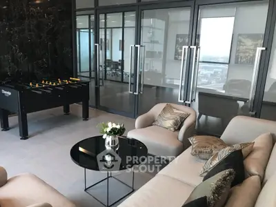Modern living room with sleek furniture and foosball table, offering a stylish and entertaining space.