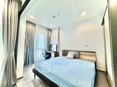 Modern bedroom with large window and stylish decor in a contemporary apartment.
