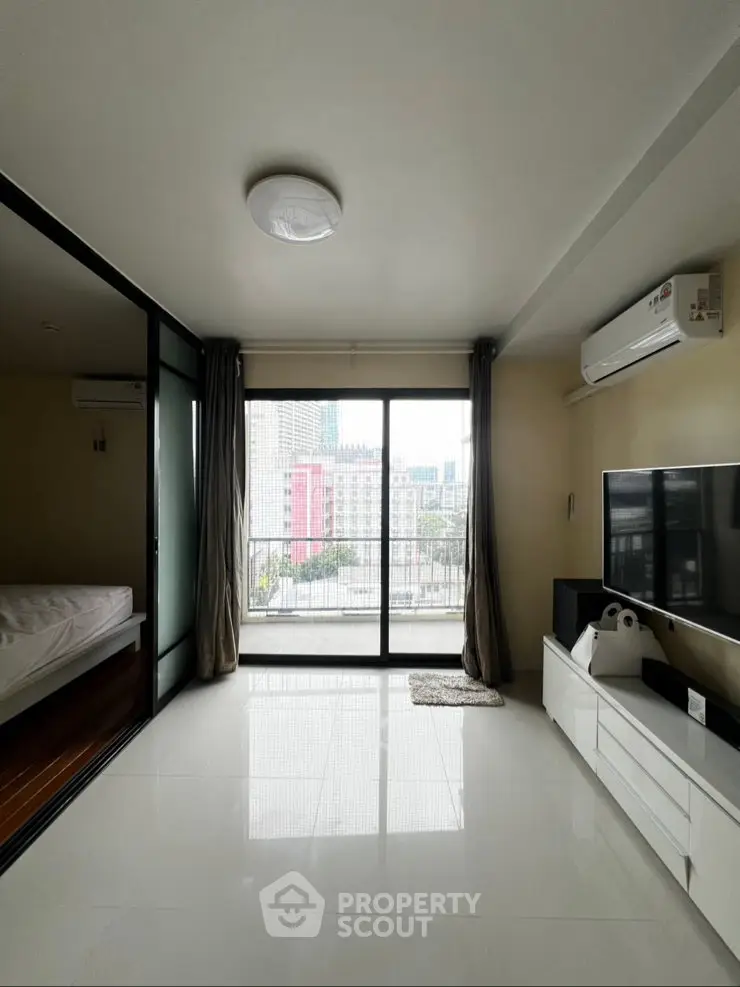 Modern living room with city view, sleek furniture, and natural light in urban apartment.