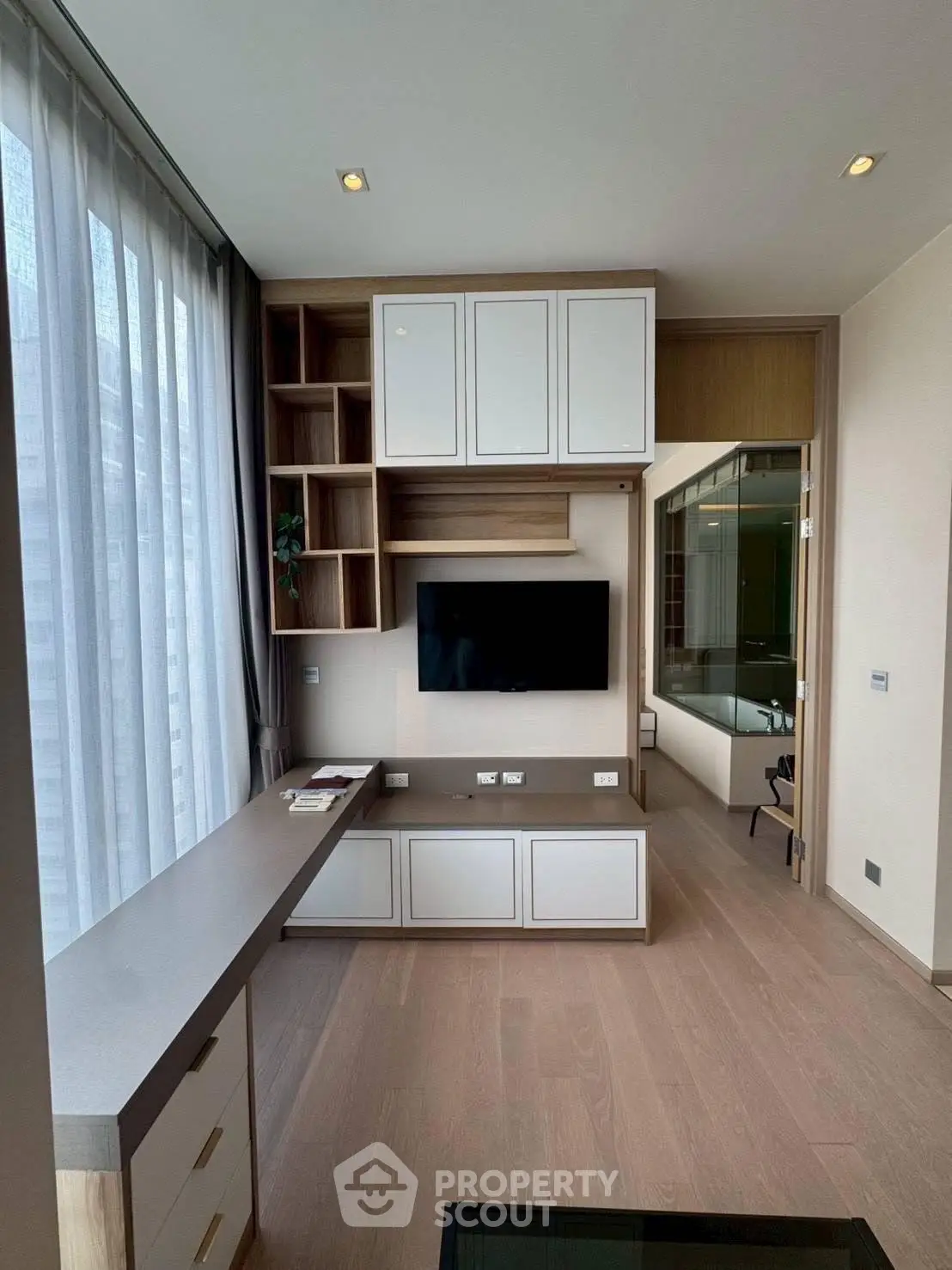 Modern living room with built-in TV unit and large window for natural light
