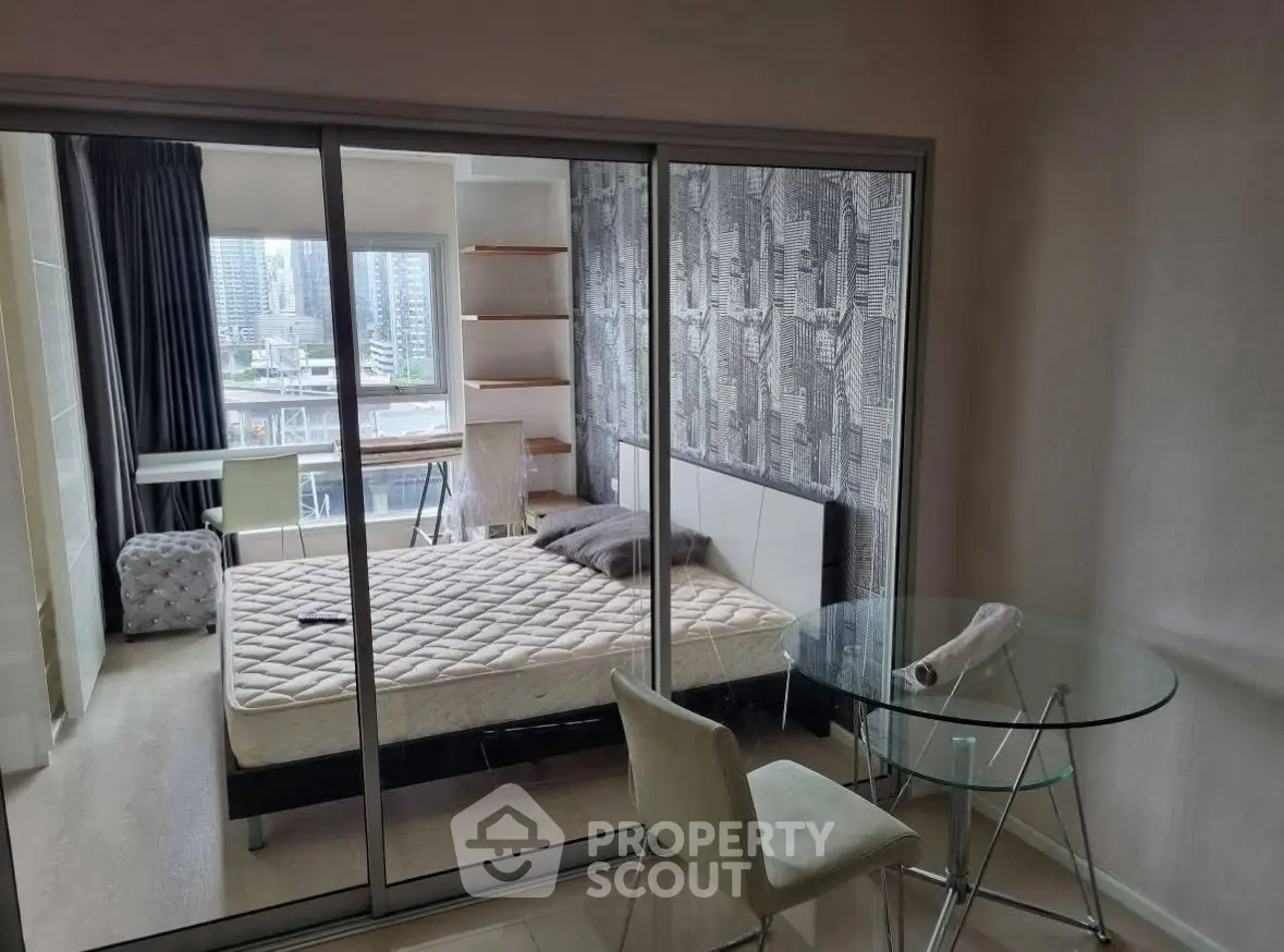 Modern bedroom with glass partition, city view, and stylish decor