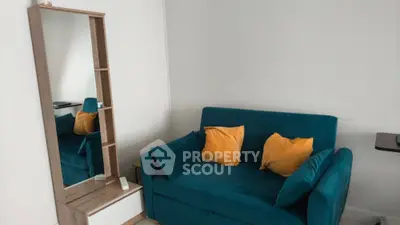 Cozy living room with teal sofa and stylish mirror cabinet